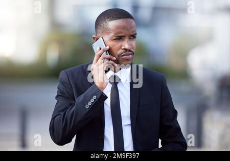 Things are getting serious. a young businessman using a phone in the city. Stock Photo