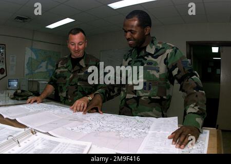 US Air Force MASTER Sergeant 'A.J.' Johnson (Left) and STAFF Sergeant Adam White review incoming aircraft locations in the flight planning office in Moron Air Base, Spain. The 496th Air Base Squadron supports the movement of aircraft to Southeast Asia. Base: Moron Air Base State: Sevilla Country: Spain (ESP) Stock Photo