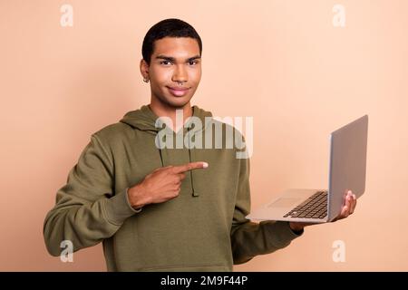 Photo of young experienced senior it developer python programmer man wear khaki hoodie direct finger new hp laptop isolated on beige color background Stock Photo