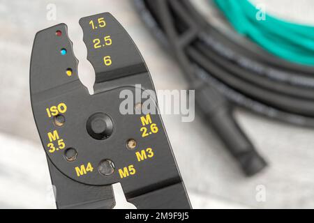 Close shot of Chinese made unbranded wire stripper & wire cutter for 26-10AWG wire (see Notes) with coiled connector cables + MC4 Solar connector Stock Photo