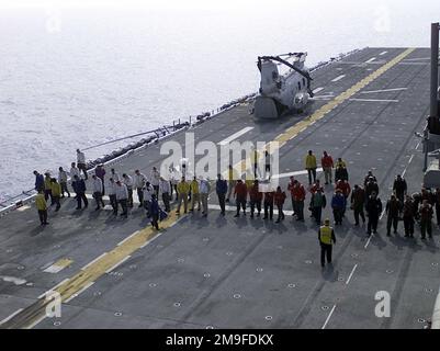 US Navy sailors, perform a Foreign Object Debris (FOD) sweep before letting any aircraft arrive or depart from the USS Essex (LHD 2) flight deck. The US Marines from the 31st Marine Expeditionary Unit (MEU) spent two months participating in various training operations on and off the coast of Okinawa, Japan, Sasebo, Japan, Pohang, Korea, and Hong Kong, China. Base: USS Essex (LHD 2) State: Okinawa Country: Japan (JPN) Stock Photo