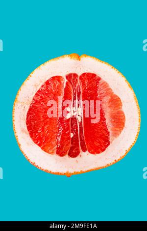 A slice of grapefruit on an isolated blue background. Clipping path. Full depth of field. Stock Photo