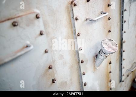 Three metal hatches plates on compressor for revision close-up with oil stains painted with gray paint bolted with studs and nuts oiler background Stock Photo