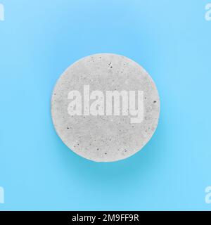 A podium made of concrete for the presentation of packaging and cosmetics, top view, on a blue background. Product display with white concrete texture Stock Photo