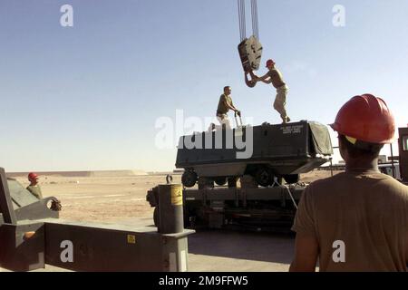 US Air Force members from the 363rd Expeditionary Maintenance Squadron and the British Royal Air Force Movements Flight, work together to lift a piece of equipment off a K-loader at Prince Sultan Air Base, Saudi Arabia, on October 25th, 2000. The 363rd and the Royal Air Force are part of the coalition force here to support Operation SOUTHERN WATCH, a military effort to enforce the no-fly and no-drive zone in Southern Iraq. Subject Operation/Series: SOUTHERN WATCH Base: Prince Sultan Air Base Country: Saudi Arabia (SAU) Stock Photo