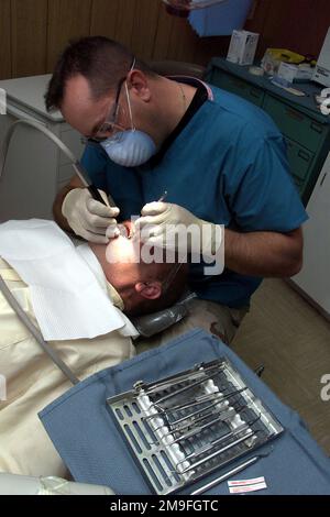 US Air Force STAFF Sergeant Brian Johnson, non-commissioned officer in charge of dental services from the 89th Medical Group, Andrews Air Force Base, Maryland, gives a cleaning to a patient at Prince Sultan Air Base, Saudi Arabia. SSGT Leger is a part of the 363rd Air Expeditionary Wing that enforces the no-fly and no-drive zone in Southern Iraq to protect and defend against Iraqi aggression in support of Operation SOUTHERN WATCH. Subject Operation/Series: SOUTHERN WATCH Base: Prince Sultan Air Base Country: Saudi Arabia (SAU) Stock Photo