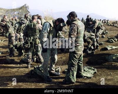 US Marines from 3rd Battalion, 12th Marine Regiment, 3D Marine Division, participate in Mission-Oriented Protective Posture response level 4 (MOPP-4) gear training, at Gun Position 99, East Camp Fuji, Japan. This training area is part of the unit's nine firing day relocation shoot, designed to enhance military occupational specialty proficiency within the artillery field. Subject Operation/Series: FOAL EAGLE 2000 Base: Marine Corps Base, Camp Fuji State: Honshu Country: Japan (JPN) Stock Photo