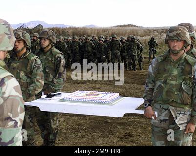 US Marines from 3rd Battalion, 12th Marine Regiment, 3D Marine Division, march out the birthday cake, during the Marine Corps 225th Birthday Cake Cutting Ceremony at Gun Position 99, East Camp Fuji, Japan. This training area is part of the unit's nine firing day relocation shoot, designed to enhance military occupational specialty proficiency within the artillery field. Subject Operation/Series: FOAL EAGLE 2000 Base: Marine Corps Base, Camp Fuji State: Honshu Country: Japan (JPN) Stock Photo