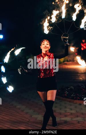 SEMIGORYE, IVANOVO OBLAST, RUSSIA - JUNE 26, 2018: Fire show. The girl spins the fiery torches. Dangerous amazing night performance Stock Photo
