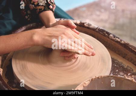 Beautiful women's hands make ceramic dishes on a potter's wheel Stock Photo