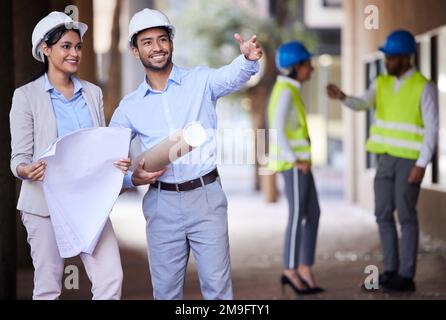 Were going to build right here. two young architects standing together in the city and having a discussion. Stock Photo