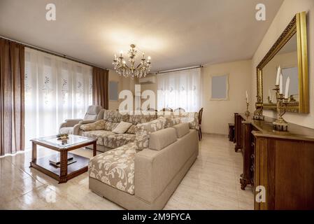 Dining room furnished with vintage-style wooden furniture with a mirror framed in golden wood Stock Photo