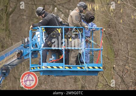 Hessen, Germany. 18 January 2023, Hessen, Frankfurt/Main: Police officers take an activist from a tree with a ladder during the evacuation of the occupation in Fechenheim Forest. The squatters were protesting against the planned expansion of the A66 with the Riederwald Tunnel, as around 1000 trees will have to be felled for this. Photo: Sebastian Gollnow/dpa Credit: dpa picture alliance/Alamy Live News Stock Photo