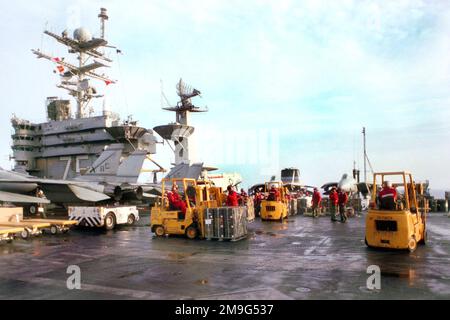 US Navy Aviation Ordnancemen spot ordnance containers for transfer to USNS SIRIUS (T-AFS 8) during a weapons offload on the flight deck of USS HARRY S. TRUMAN (CVN 75). Base: USS Harry S. Truman (CVN 75) Stock Photo