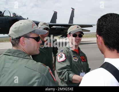 US Air Force Captain Mike Quintini (center) and US Air Force Major Bill Pinter (left), both from RAF Lakenheath, England, explain the specifications of an F-15E Strike Eagle fighter aircraft to an air show visitor during the French Air Base 25, Istres, Air Show. CPT Quintini is an F-15E weapons systems officer and MAJ Pinter is an F-15E pilot with Lakenheath's 494th Fighter Squadron. Two Strike Eagles from Lakenheath, a C-17 Globemaster III from Charleston Air Force Base, South Carolina, temporarily based at Ramstein Air Base, Germany, and a B-1B Lancer bomber from the Kansas Air National Guar Stock Photo