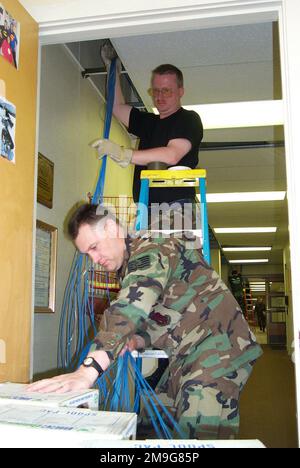 127th Communications flight personnel, Selfridge Air National Guard Base Michigan, deployed to Elmendorf AFB Alaska, work together to install 29 miles of LAN cable to connect 250 computers to the bases computer network. In addition they will be connecting 9,500 feet of fiber optic cable to the bases existing computer network. Base: Elmendorf Air Force Base State: Alaska (AK) Country: United States Of America (USA) Stock Photo