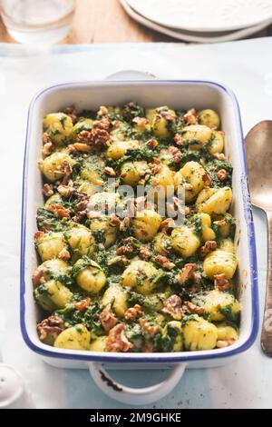 Italian gnocchi with spinach and walnuts bake Stock Photo
