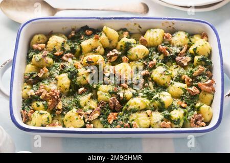 Italian gnocchi with spinach and walnuts bake Stock Photo