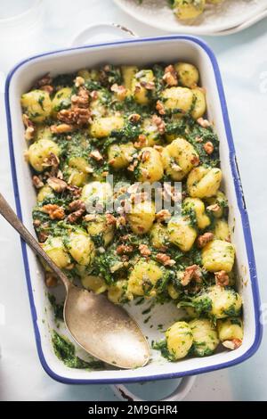 Italian gnocchi with spinach and walnuts bake Stock Photo