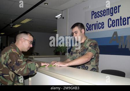 Passenger Service Center Agent, AIRMAN SENIOR AIRMAN Robert McKinley, USAF, (right), 723rd Air Mobility Squadron, Air Mobility Command Terminal, Ramstein Air Base, Germany, assists customer Sergeant Wayne Linton, USA, a mechanic on Coleman Barracks, Mannheim Germany with flight information. Base: Ramstein Air Base State: Rheinland-Pfalz Country: Deutschland / Germany (DEU) Scene Major Command Shown: USAFE Stock Photo