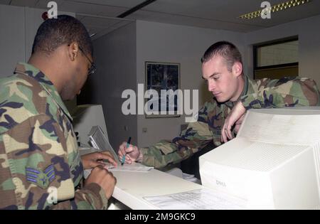 Passenger Service Center Agent, AIRMAN First Class Casey Keller, USAF, 723rd Air Mobility Squadron, Air Mobility Command Terminal, Ramstein Air Base, Germany assists customer with flight information. Base: Ramstein Air Base State: Rheinland-Pfalz Country: Deutschland / Germany (DEU) Scene Major Command Shown: USAFE Stock Photo