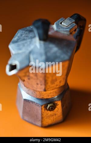 Close up of a very old italian coffee pot on orange Stock Photo