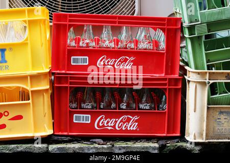 TOKYO, JAPAN - October 8, 2022: Crates containing empty glass bottles, including Coca-Cola ones, outside a liquor store in Tokyo's Kanda area. Stock Photo