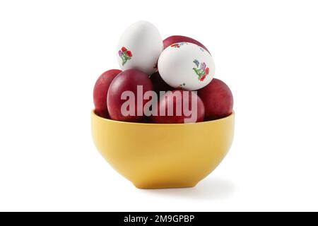 Painted easter eggs in yellow ceramic bowl isolated on white Stock Photo