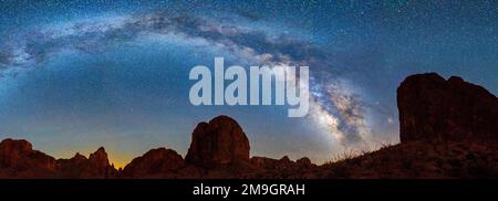 Landscape with rock formations in desert under Milky Way galaxy in sky at night, Kofa Queen Canyon, Kofa National Wildlife Refuge, Arizona, USA Stock Photo