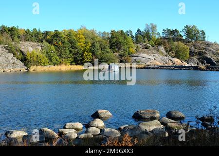 View over the strait between two islands with autumn colored trees behind  and floating sauna, Vallisaari, Helsinki Biennial 2021 Stock Photo - Alamy