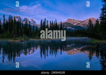 Landscape with Three Sisters Mountains, Mount Lawrence Grassi and lake at sunset, Alberta, Canada Stock Photo