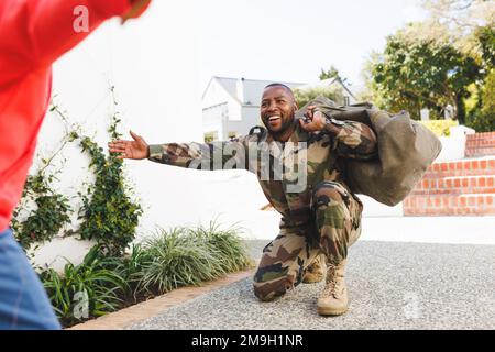 Happy african american father wearing military uniform and his son embracing Stock Photo