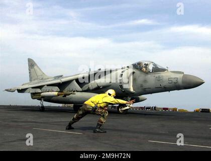 US Navy (USN) CHIEF Aviation Boatswain's Mate (ABC) Steve Guarjardo, an Aircraft Handling Officer aboard the USN WASP CLASS: Amphibious Assault Ship, USS BATAAN (LHD 5), signals the rolling launch of a US Marine Corps (USMC) AV-8B Harrier aircraft off the flight deck. Base: USS Bataan (LHD-5) Stock Photo