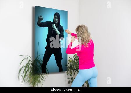 Fit woman in sportswear doing exercise mat at home using projector watching tutorial. Female coach has a virtual class on projector. Healthy and Stock Photo