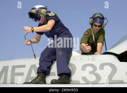 US Marine Corps (USMC) Sergeant (SGT) Kimberly Tomasino (foreground), and SGT Brian Bushey, both assigned to Marine Fighter Attack Squadron 'All Weather' 232 (VMFA 'AW'-232) changes out a fuel quantity transmitter on a USMC F/A-18 Hornet aircraft at Korat AB, Thailand, during Exercise COPE TIGER '02. Cope Tiger is an annual, multinational exercise in the Asia-Pacific region which promotes closer relations and enables air force units in the region to sharpen air combat skills and practice interoperability with US Forces. Base: Korat Air Base Country: Thailand (THA) Stock Photo