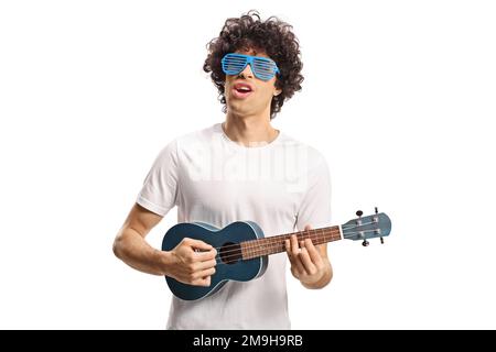 Young man with curly hair and shutter glasses playing ukulele and singing isolated on white background Stock Photo