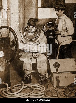 A 1930 British diver with his equipment including telephone, air pump, heavy weights etc.. Stock Photo