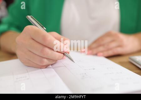Female manager takes notes on paper while planning her business. Stock Photo