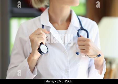 Close up of female cardiologist holding her stethoscope in hospital. Stock Photo