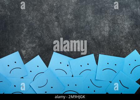 Blue sticky notes blank with drawing sad face on black background with copy space ready for your message. Blue Monday and mental health concept idea. Stock Photo