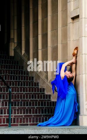 Acrobat in blue dress stretching on staircase, University of Washington, Seattle, Washington State, USA Stock Photo