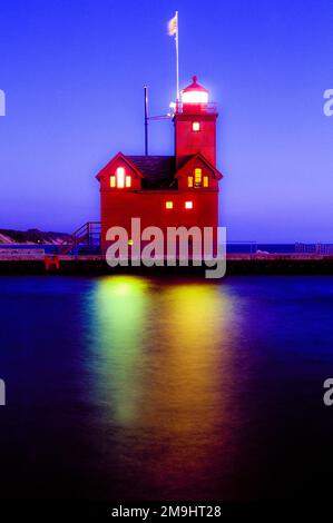 Lighthouse illuminated over sea in Big Red Light, Holland, Michigan, USA Stock Photo