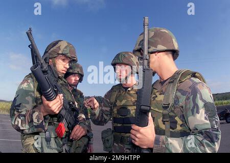 020507-F-6844O-009. [Complete] Scene Caption: US Air Force (USAF) AIRMAN First Class (A1C) Jasen Rodriguez (left) armed with a 5.56mm M16A1 rifle with a 40mm M203 grenade launcher, listens to the instruction of his team chief, USAF First Lieutenant (1LT) Tim McCarty (center) as STAFF Sergeant (SSGT) David Ball (background), and A1C Brad Terry, look on. They are member of the 45th Space Wing (SW) Security Forces Squadron (SFS), preparing to participate the marksmanship competition at Vandenberg Air Force Base (AFB) California (CA), during Exercise GUARDIAN CHALLENGE 2002. Guardian Challenge, a Stock Photo