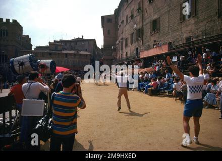 Siena Italy Tourists and Locals watching the Palio di Siena a Horse Raceheld twice a year at the Piazza Del Campo each Jockey Represents one of the Ten out of 17 Contrade Stock Photo