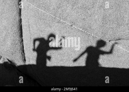 children playing with shadows on a rock in Joshua Tree National park Stock Photo