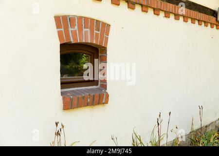 A window in a building, a plastered wall, a brick lintel. Stock Photo
