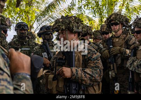 U.S. Marine Corps Staff Sgt. Jose Raynund-Hamoy, an infantry Marine with India Company, 3rd Battalion, 25th Marine Regiment, 4th Marine Division, talks to Mexican Marines and U.S. Marines before conducting their culminating event during exercise Tradewinds 2022 (TW22) at Belmopan, Belize, on May 19, 2022. The culminating event took place at the National Police Training Academy which consisted of various events occurring: riot control, close quarter combat and tactical field care. TW22 is a U.S. Southern Command-sponsored Caribbean-focused multi-dimensional exercise conducted in the ground, air Stock Photo