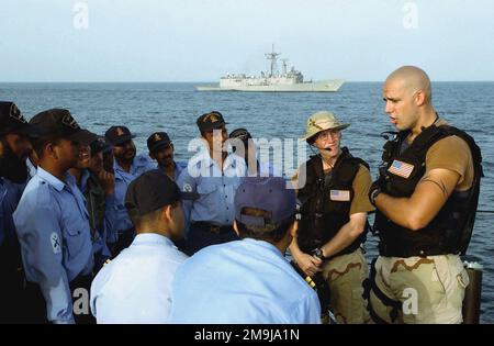 020926-N-4309A-027. [Complete] Scene Caption: US Navy (USN) Hull Maintenance Technician Second Class (HT2) Robert Kinast talks to members of the Pakistani Navy Tariq (Amazon) Class Type 21 Frigate PNS SHAHJAHAN (D 186) during a Visit Board Search and Seizure (VBSS) drill as part of Exercise INSPIRED SIREN '02. The SHAHJAHAN and the USN Oliver Hazard Perry Class Guided Missile Frigate USS REUBAN JAMES (FFG 57), in the background, are currently participating in Exercise INSPIRED SIREN '02 a US and Pakistani bilateral military exercise involving surface and air forces from the two nations to enha Stock Photo