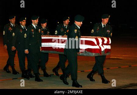 A US Army (USA) Honor Guard Team, from 1ST Battalion, 1ST Special Forces Group (Airborne) transports a flag draped tranfer case carrying the remains of USA Sergeant First Class (SFC) Mark Wayne Jackson, across the flight line at Kadena Air Base (AB) Okinawa, Japan. SFC Jackson was assigned to A/Company, 2nd Battalion, 1ST Special Forces Group (SFG) (Airborne), Operational Detachment Alpha 142, and was killed during a bombing attack at an open-air restaurant, outside the gate at Camp Enrile Malagutay, Zamboanga, Philippines. (Substandard image). Base: Kadena Air Base State: Okinawa Country: Jap Stock Photo