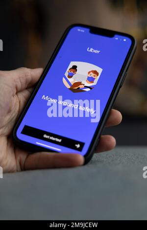 Hand holding a smartphone with Uber icon on screen. Move around safely. IPhone with a transportation app logo. Amsterdam, Netherlands 2023.01.01 Stock Photo